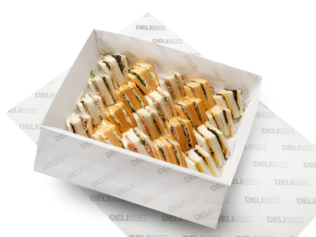Schaal met luxe clubsandwiches, gevarieerd belegd met kaas, vleeswaren en gerookte zalm.